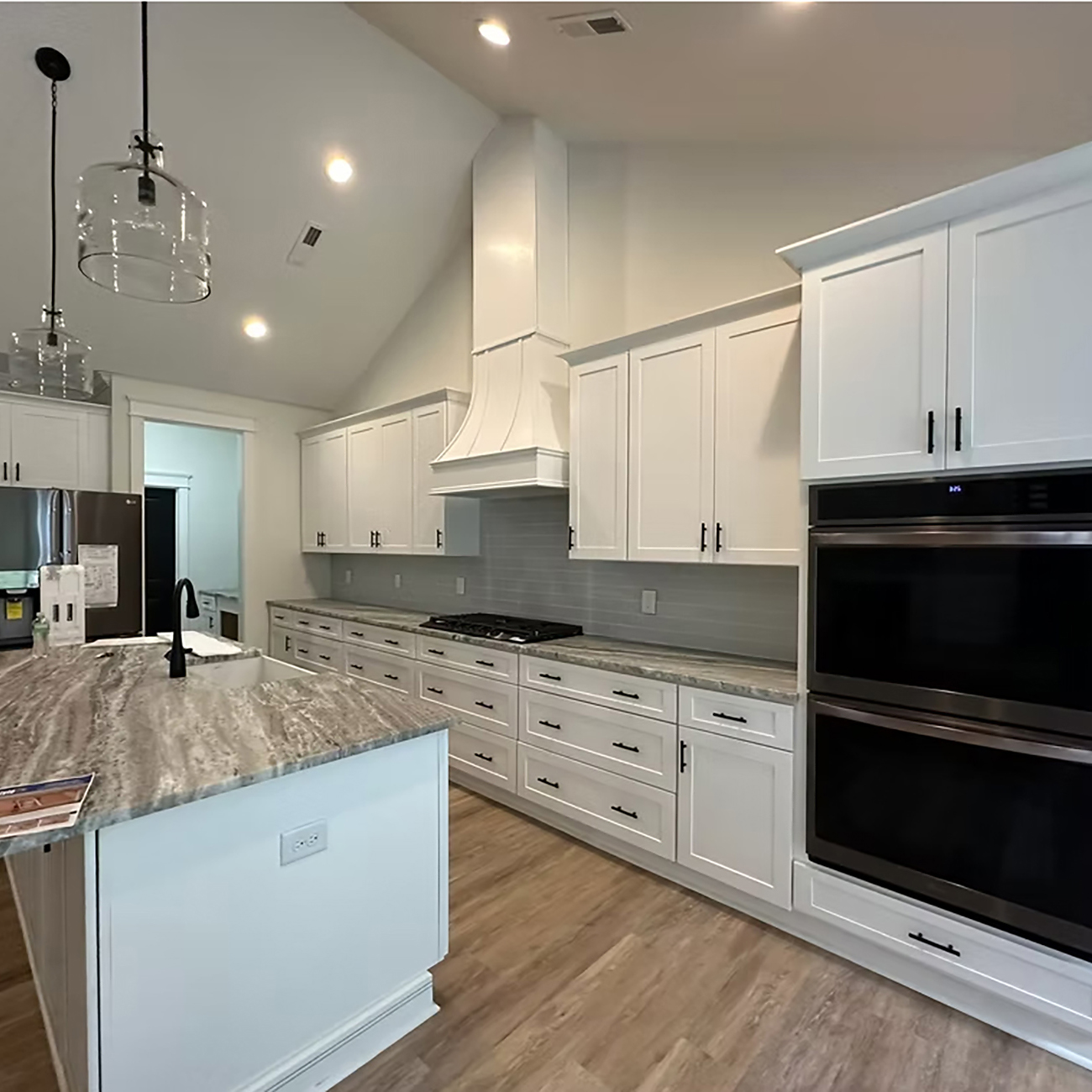Modern kitchen with white cabinets, tile backsplash, and upgraded countertops