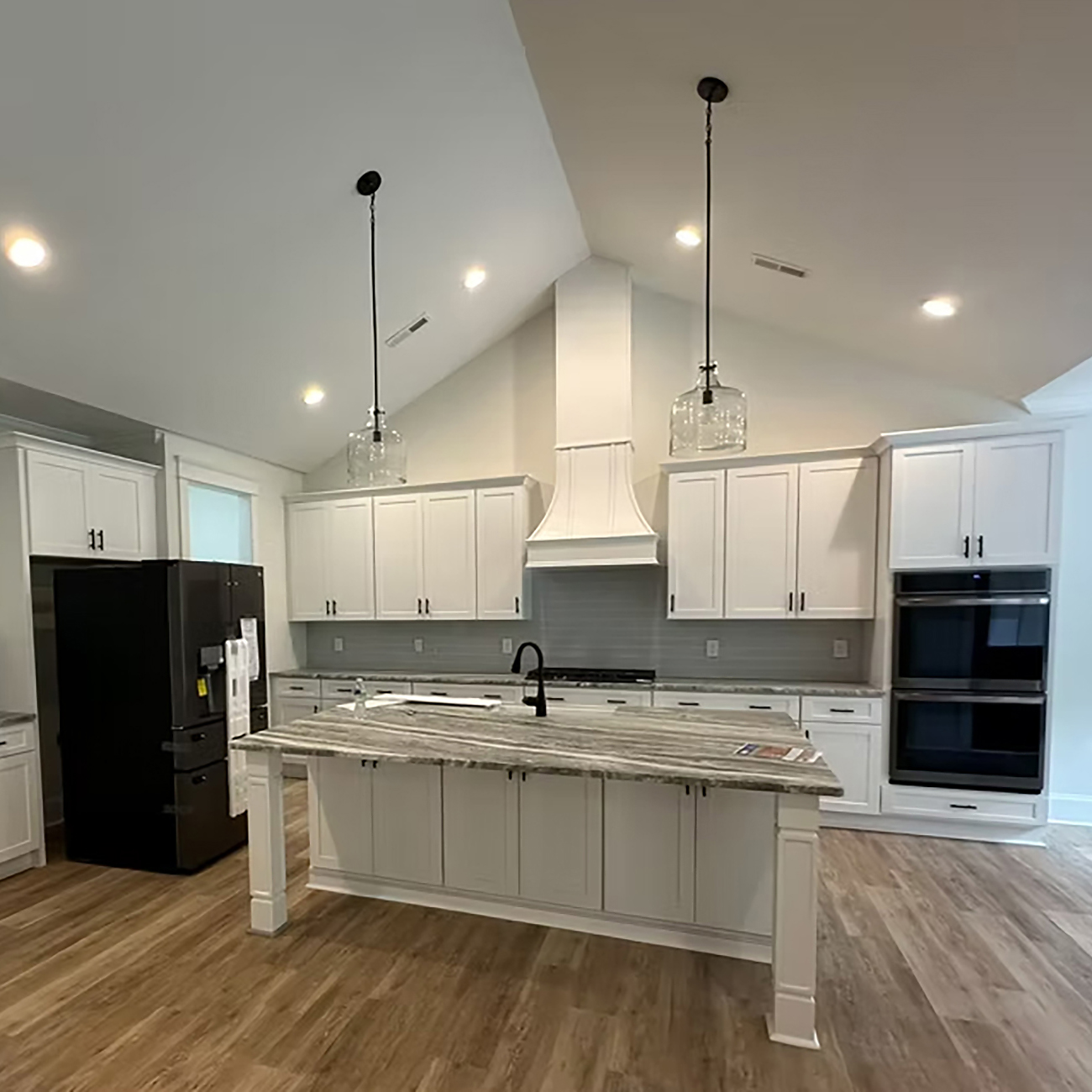Kitchen remodel with bright cabinetry, updated countertops, and modern pendant lighting